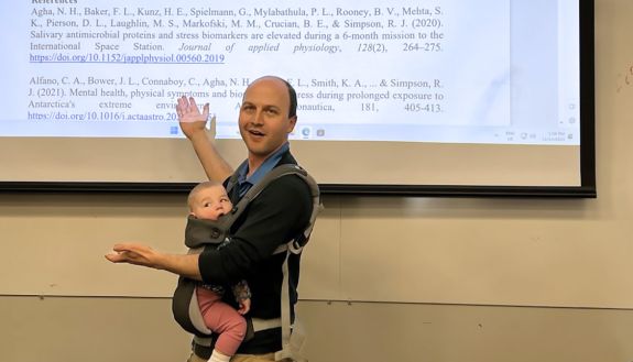 Dan Buckland teaching with a baby.