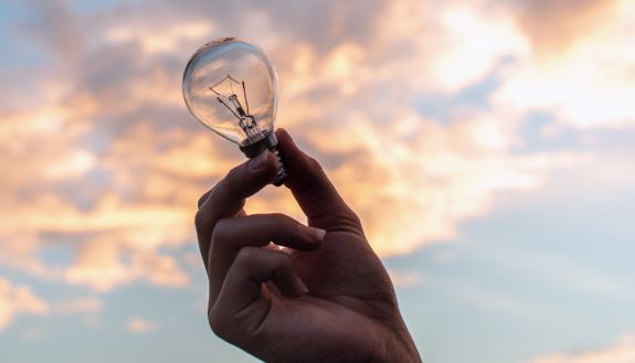 A hand holding a lightbulb.