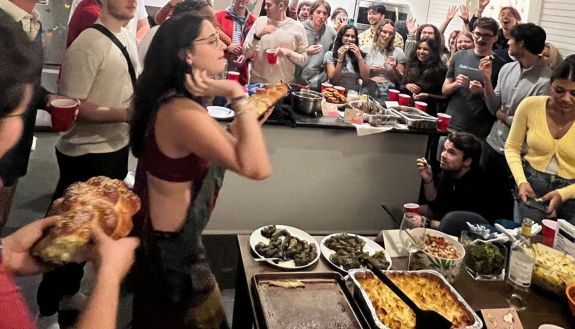 students tossing challah at a Shabbat meal at the Center for Jewish Life.