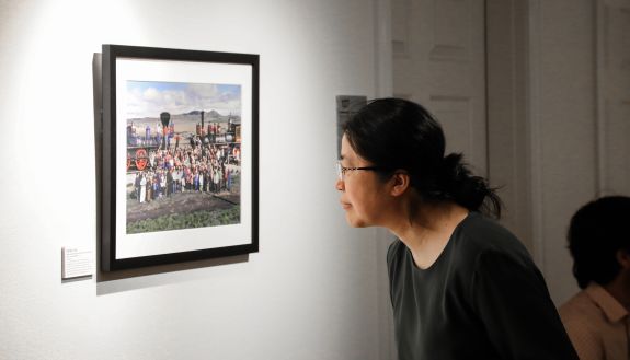 Person viewing a photograph of a railroad by photographer Corky Lee.