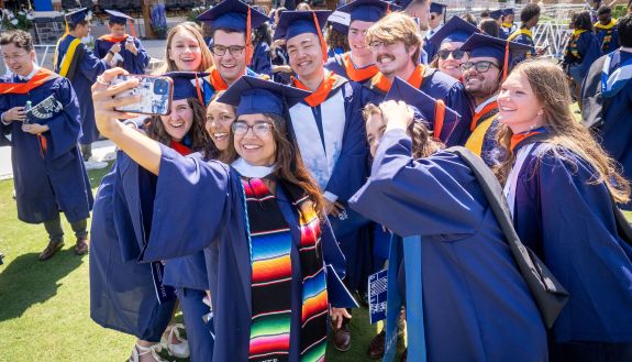 students pose for a selfie at commencement