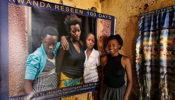 Yvette stands next to the portrait Bill Bamberger made with her and her two cousins in 2017. The photo is on display in the home of her Aunt Terese.