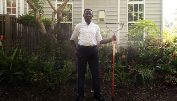 Eric Mvukieyeh with a rake in a garden