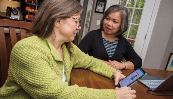 Two people talking next to an iPad