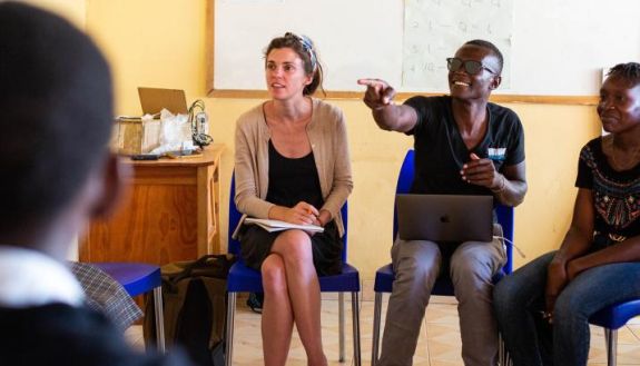 Savannah Johnson (sitting at left) tests out questions for a focus group discussion on relationships and mental health with students at the Wiser Girls' Secondary School in Muhuru Bay, Kenya. Photo by Veasey Conway