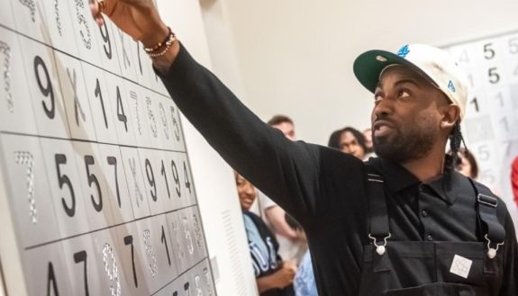 Person pointing to a large canvas of numbers