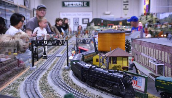 People watch a model train.