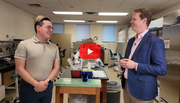 Two people standing and talking in a lab
