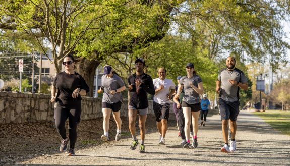 A group of people runs on a gravel path on Duke's East Campus