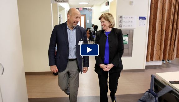 Craig Albanese and Mary Klotman talk while walking in hospital hallways