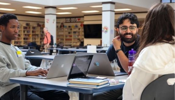 People sitting at a table in a library talking
