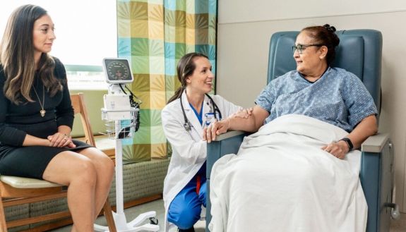Two women in a doctor's office talking to a doctor