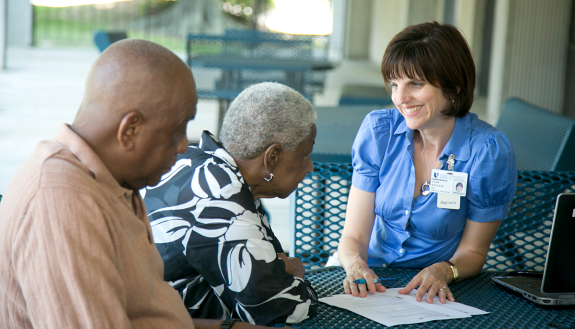 Dr. Teah Bayless talks with an elderly couple