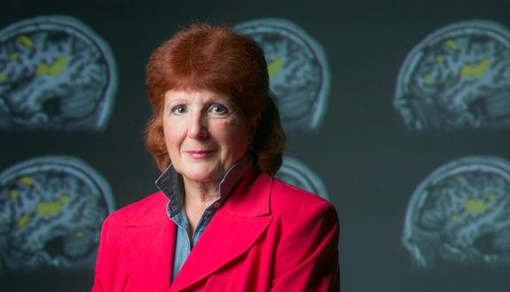 Edna Andrews, photographed in front of images of brain scans. Photo by Megan Mendenhall/Duke Photography