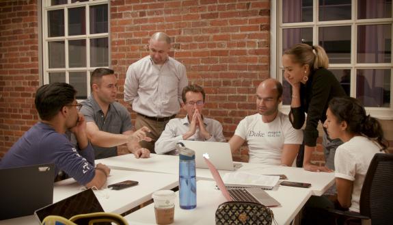 Eric Richardson (left side in gray), Associate Professor of the Practice in Biomedical Engineering and Director of Duke Design Health, reviews projects with students and faculty.