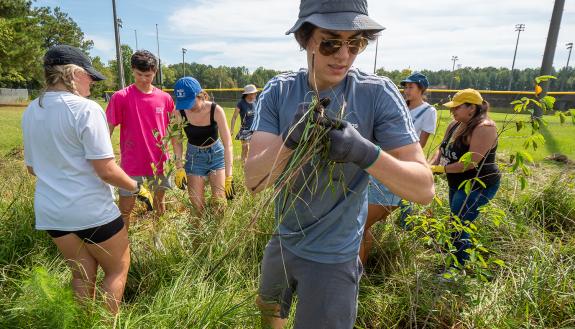 First-year students spent a morning at Durham’s Southern School of Energy and Sustainability mulching tree beds and creating protection for new tree plantings. (Bill Snead/University Communications)