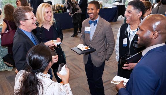 Duke University President Vincent E. Price speaks with guests at the reception following Tuesday's Presidential Awards ceremony. Photo by Les Todd.