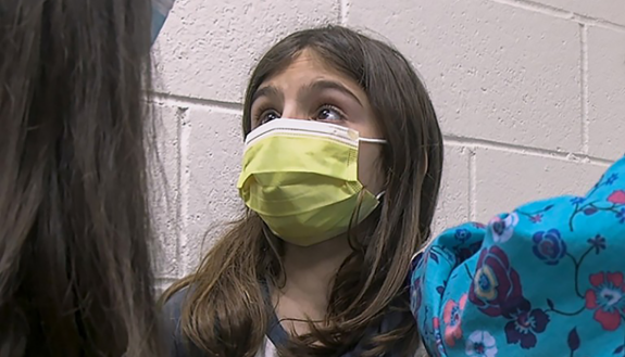 child with mask getting vaccine