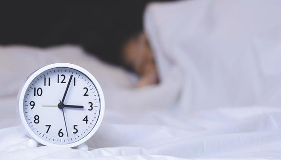 A clock and a person sleeping.