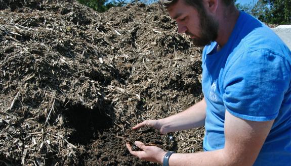 Nick Schwab shows off decaying plant matter from inside a compost pile at Sarah P. Duke Gardens. Photo by Stephen Schramm.