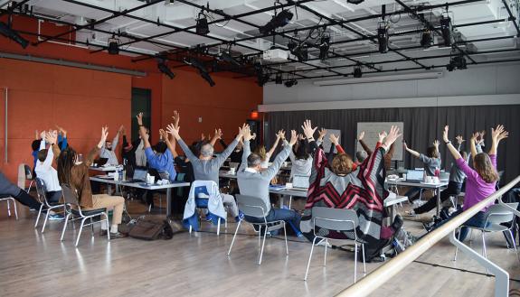 Faculty writers get their bodies moving during the session.