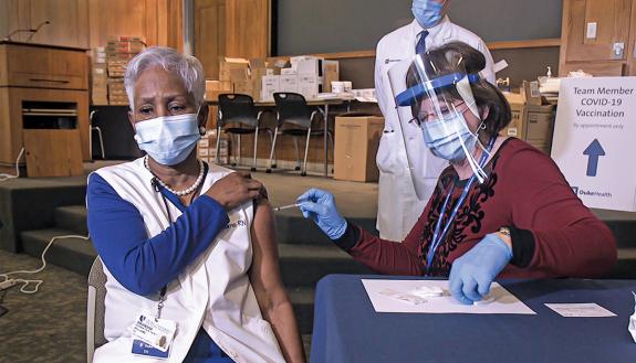 Nursing Program Manager Rita Oakes administers Duke’s first COVID-19 vaccination to Faye Williams on December 14. Photo by Shawn Rocco.