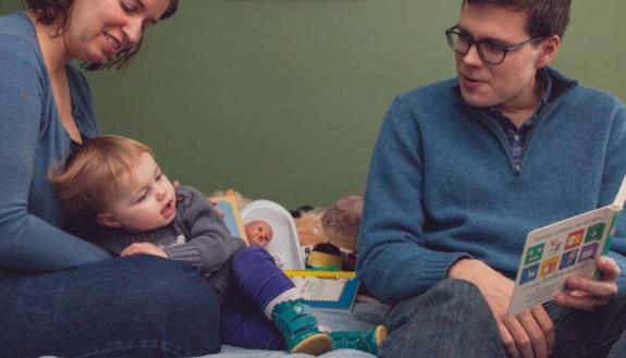 Rachel Scheckter and James Soliah reading to baby Eleanor