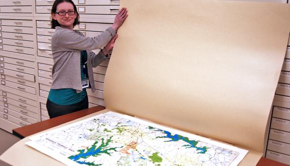 Duke University Archives Records Manager Hillary Gatlin shows off a map of Duke Forest recently transferred to the archives. Photo by Stephen Schramm.