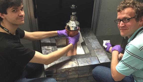 A photo of graduate students Bjorn Scholz and Grayson Rich adjusting the cesium iodide detector