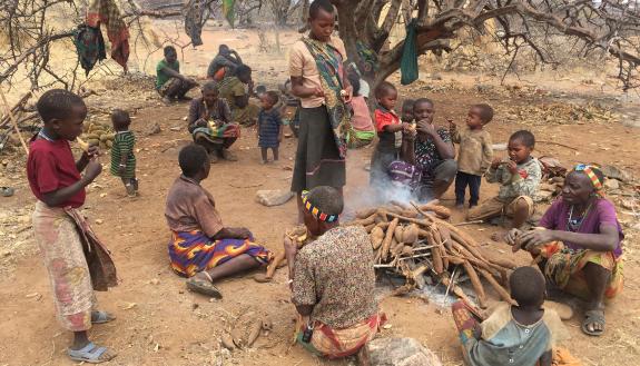 A group of Hadza women share a meal of roasted tubers. Food sharing allows them to spend more energy to find food, knowing they won’t starve if they return to camp empty-handed. (Photo – Herman Pontzer)