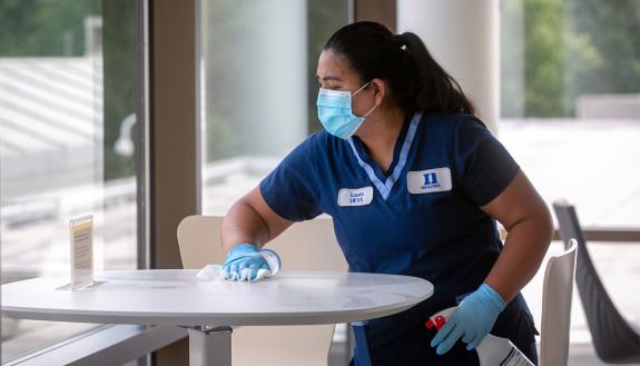 Duke Housekeeper Specialist Laura Valdovinos Robles cleans a table at the Fuqua School of Business. Photo courtesy of University Communications.