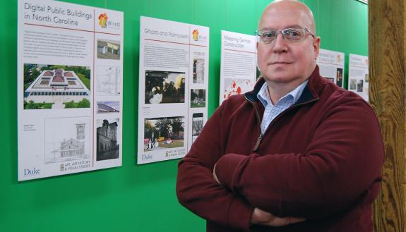 John Taormina standing in front of a green wall.