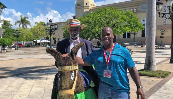 Larry Dublin in a town square with a donkey.