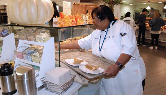 Senior Lead Food Service Worker Georgia Terrell tends to a display of desserts during the Thanksgiving meal at East Campus Marketplace. Photo by Stephen Schramm.