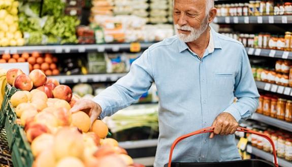 older man buying fruit in grocery store