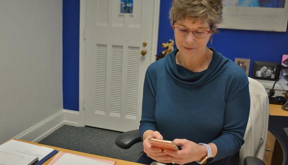Mary Greenway, executive assistant to Provost Sally Kornbluth, works from her cellphone in her office in February. Photo by Jonathan Black.