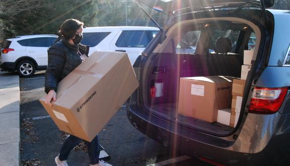 Karen Jackson of the Duke University School of Nursing loads boxes of face masks for colleagues into her car last week. Photo by Stephen Schramm.