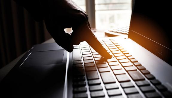 A hand using a keyboard.