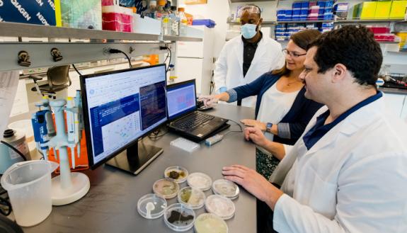 Duke graduate students Joshua Crittenden (left) and Daniel Rodriguez (right) discuss their microbiome engineering research with their advisor, Claudia Gunsch. The group's expertise in engineering microbes to remediate polluted environments will now be foc