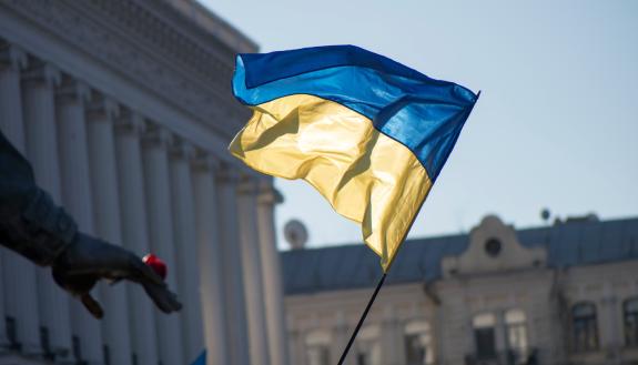 A Ukrainian flag waving in front of a building. 