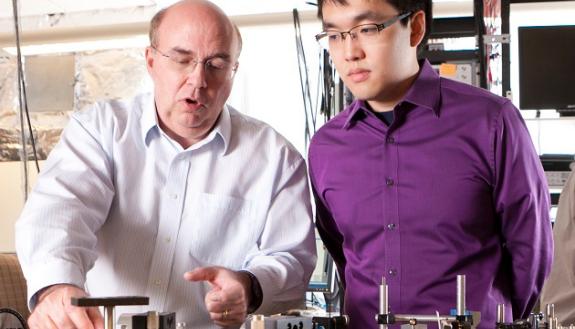 Duke Professor Warren Warren coaches a student in a laser lab