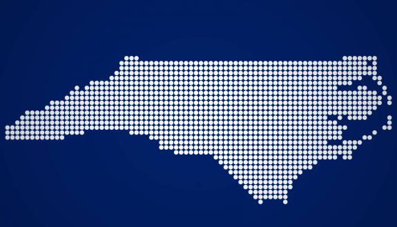 White outline of the state of North Carolina on a dark blue background.
