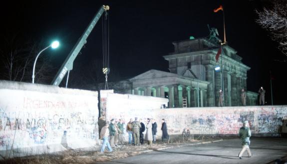A crane removes part of the Berlin Wall. Photo courtesy Wikimedia Commons