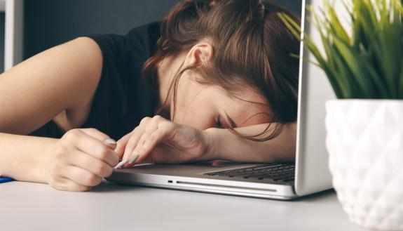 A woman asleep at her desk.