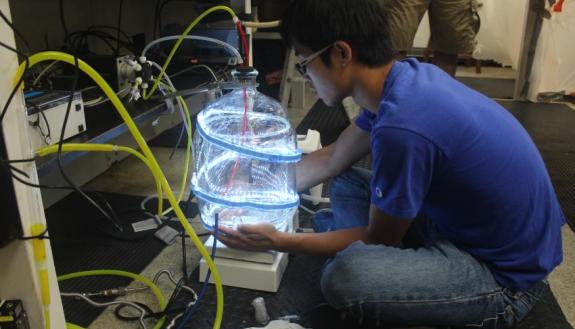 Duke Univ. PhD student Weiyi Tang sets up a flow-through incubator to measure oceanic nitrogen fixation on a research cruise. (Credit: Karyn Perdue, Museum of Life and Science, Durham, N.C.)