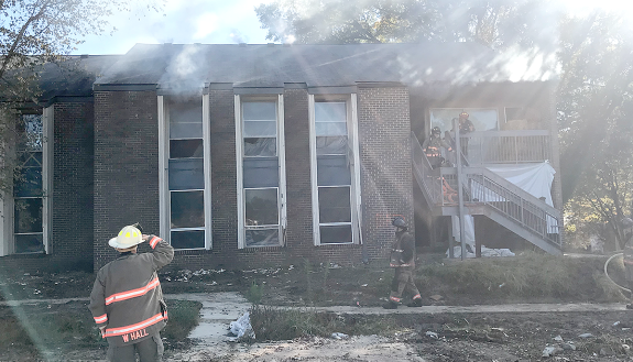 Durham firefighters enter a burning Central Campus apartment during training exercises. Photo by Hector 