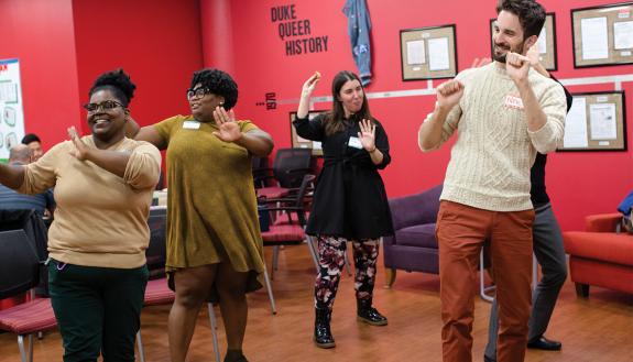 Nicholas Antonicci, far right, director of CSGD, and Brittney Brown, far left, office coordinator at the CSGD, dance with friends and colleagues from WorkOUT, the LGBTQ staff and faculty group during a potluck. Photo by Justin Cook.