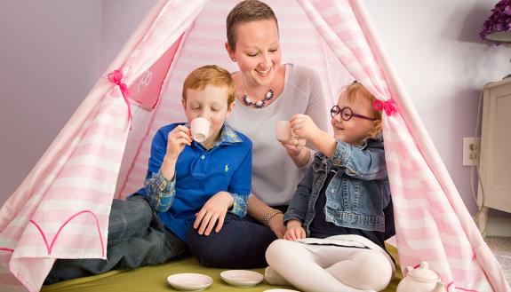 Lori Elliott, Duke breast cancer patient, plays tea time with her son James, 6, and daughter Grace, 3, at their Raleigh home. 