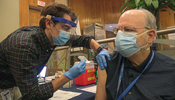 Dr. Barton Haynes receives his first dosage of the COVID vaccine.