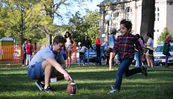 Duke students and local refugee youth kick the football at a social event April 4